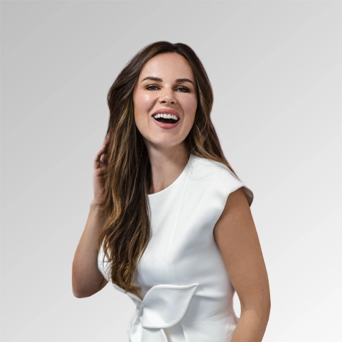 Confident young woman in a stylish white dress radiating positivity and charm.