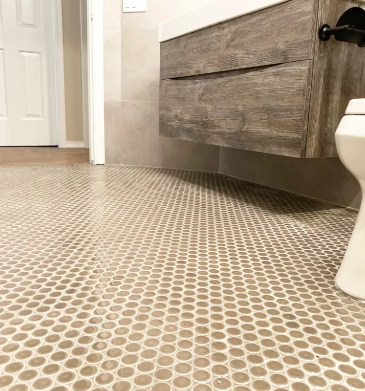 Elegant modern bathroom featuring mosaic tile flooring and a sleek wooden vanity.