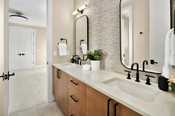 Sophisticated modern bathroom featuring dual sinks, elegant mirrors, and stylish decor accents.