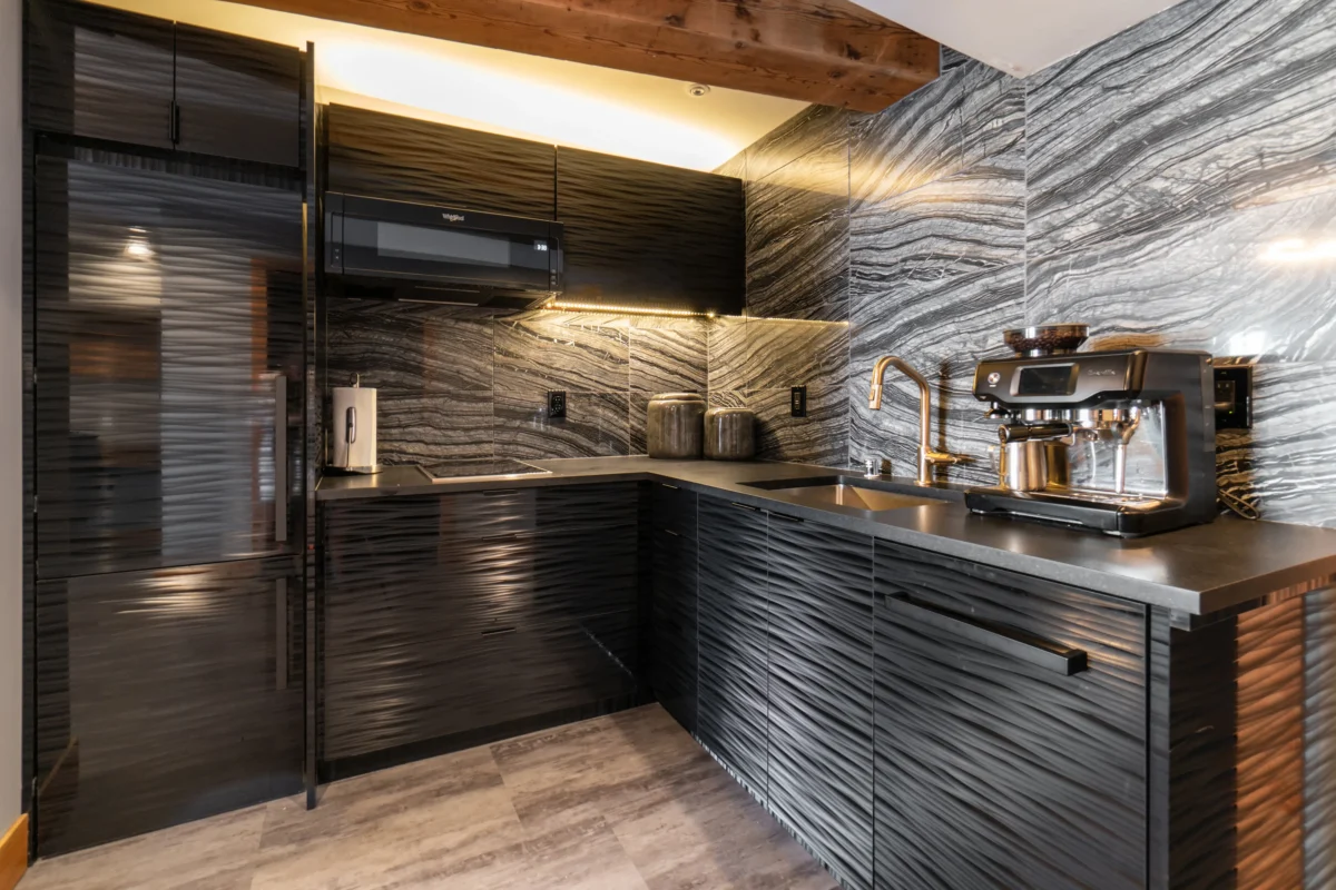 Contemporary kitchen featuring dark cabinetry, luxurious marble, and high-end appliances.