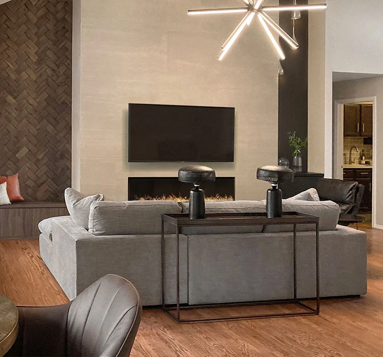 Modern living room design featuring a cozy gray sectional, elegant lighting, and warm wooden accents.