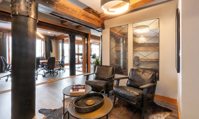 Cozy modern office interior featuring black leather seating and inviting natural light.