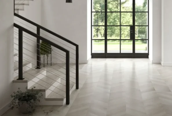 Sleek modern staircase in a sunlit room with minimalist decor and greenery.