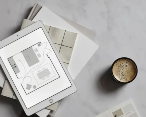 Stylish modern workspace with iPad showcasing a minimalist interior design floor plan and coffee.