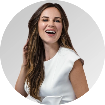 Joyful woman in a white outfit with long hair and a warm smile.