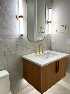 Elegant modern bathroom featuring a floating vanity, gold accents, and sleek neutral tones.