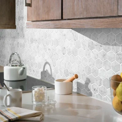 Stylish modern kitchen featuring hexagon tile backsplash, elegant accents, and fresh fruit decor.