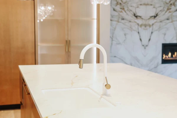 Elegant modern kitchen featuring a sleek island, gold accents, and luxurious marble design.