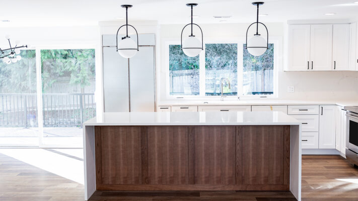 Modern kitchen design featuring a quartz island, wood accents, and stylish pendant lighting.