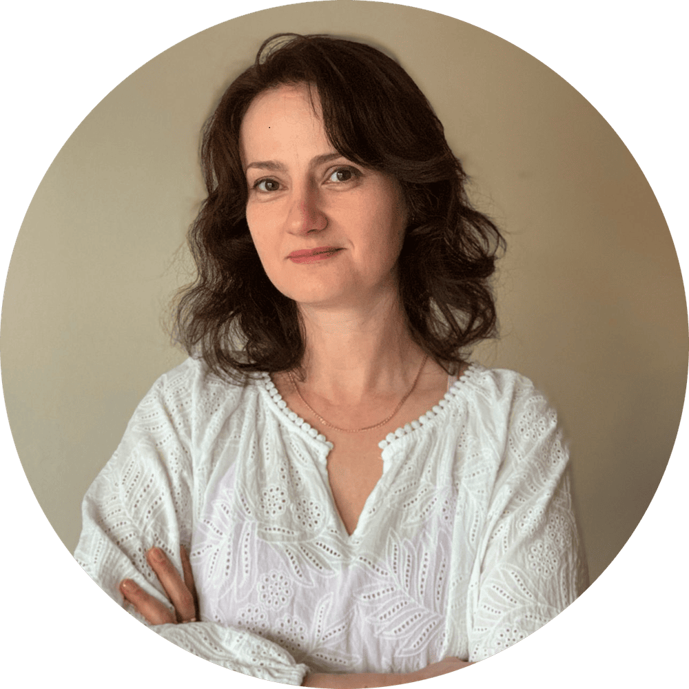 Confident professional woman in elegant blouse, exuding warmth and poise against a soft background.