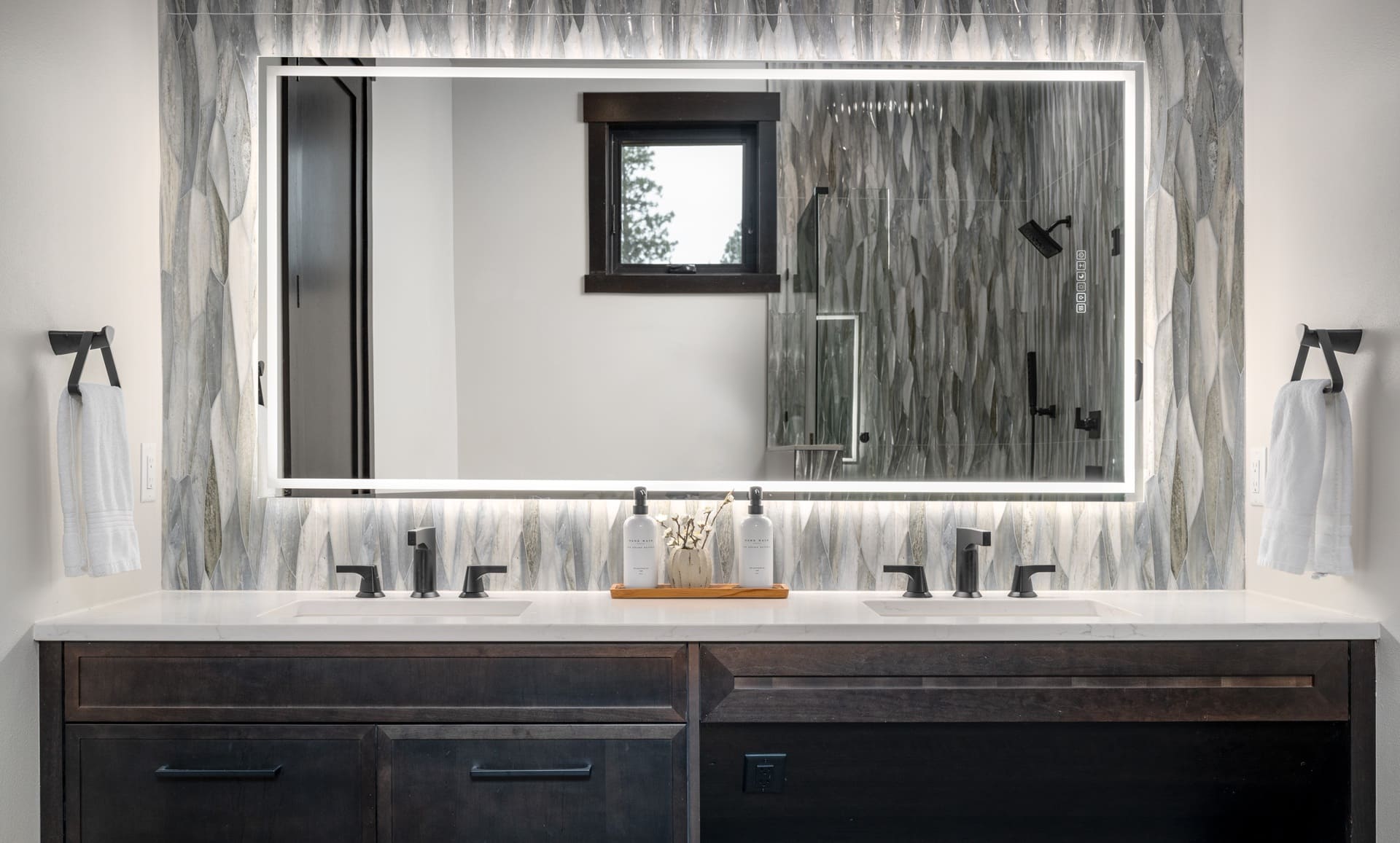 Stylish modern bathroom with double sink vanity, glass shower, and elegant design elements.